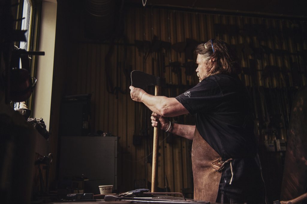 Blacksmith sheathing an axe