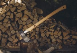 axe on top of log by wood pile